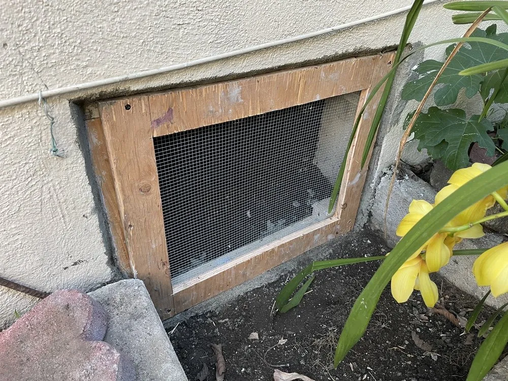 A crawlspace opening protected with a rodent-resistant screen